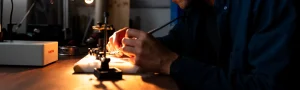 Person working with a soldering iron.