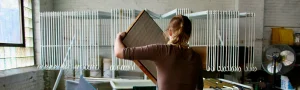 Person working with paper in an art studio.