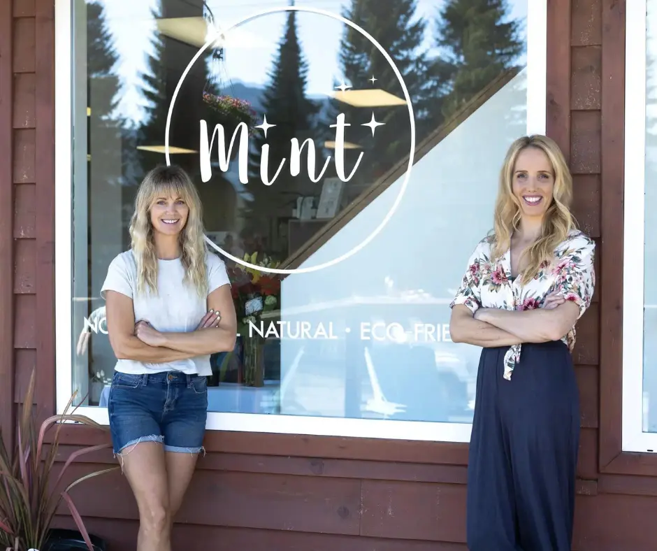 Mint Cleaning founders stand by a shop window with the mint cleaning logo.