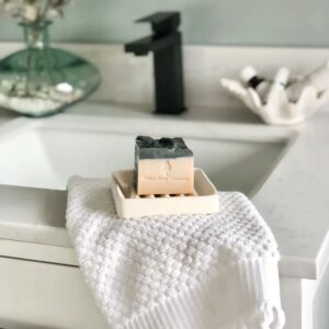 A fresh bar of soap sits by a bathroom sink.
