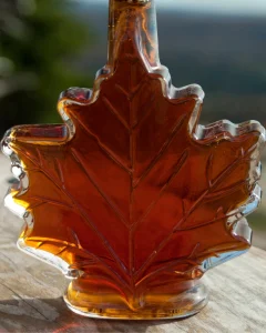 Maple syrup in a maple leaf shaped bottle.